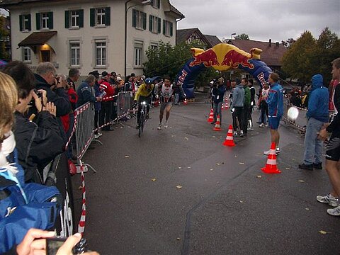 Der Velofahrer übergibt dem Läufer.