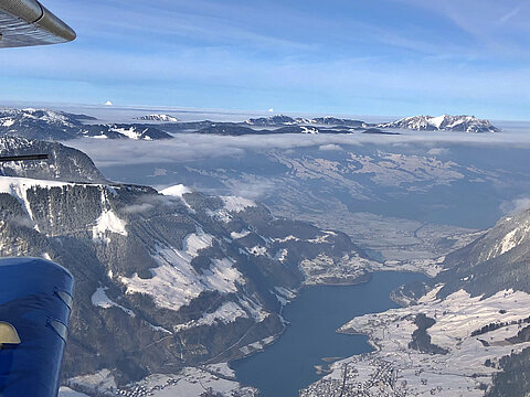 Vorne Lungernsee mit Brünigpass. Wolken Kernkraftwerk Gösgen und Leibstadt.