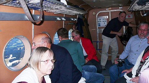 Die Passagiere beim diskutieren auf dem Rückflug.